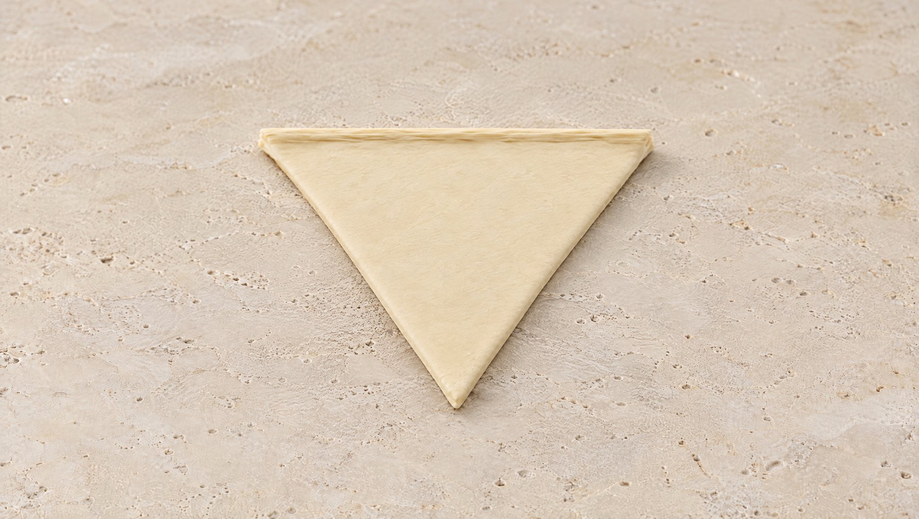 Un triángulo plano de masa de croissant sobre piedra